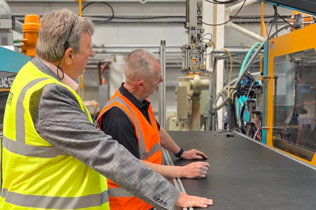 Steve Bays observing the PaveVent™ pothole relief device undergoing physical manufacturing and testing on a conveyor.